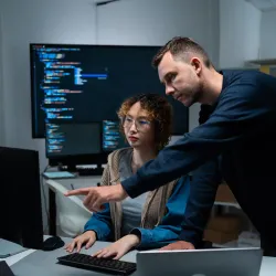 2 professionals looking at a screen
