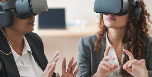 2 women executives wearing VR headsets